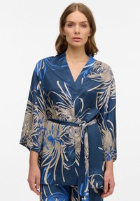 Robe in satin con motivo floreale blu, dotata di colletto sciallato, maniche a tre quarti e una cintura coordinata che stringe in vita.