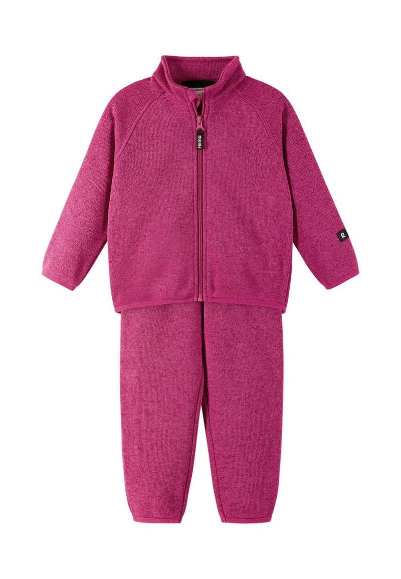 Bluza z zamkiem w kolorze fuksji z wysokim kołnierzem i długimi rękawami, zestawiona z dopasowanymi spodniami. Miękki, teksturowany materiał z niewielką ilością dodatków.