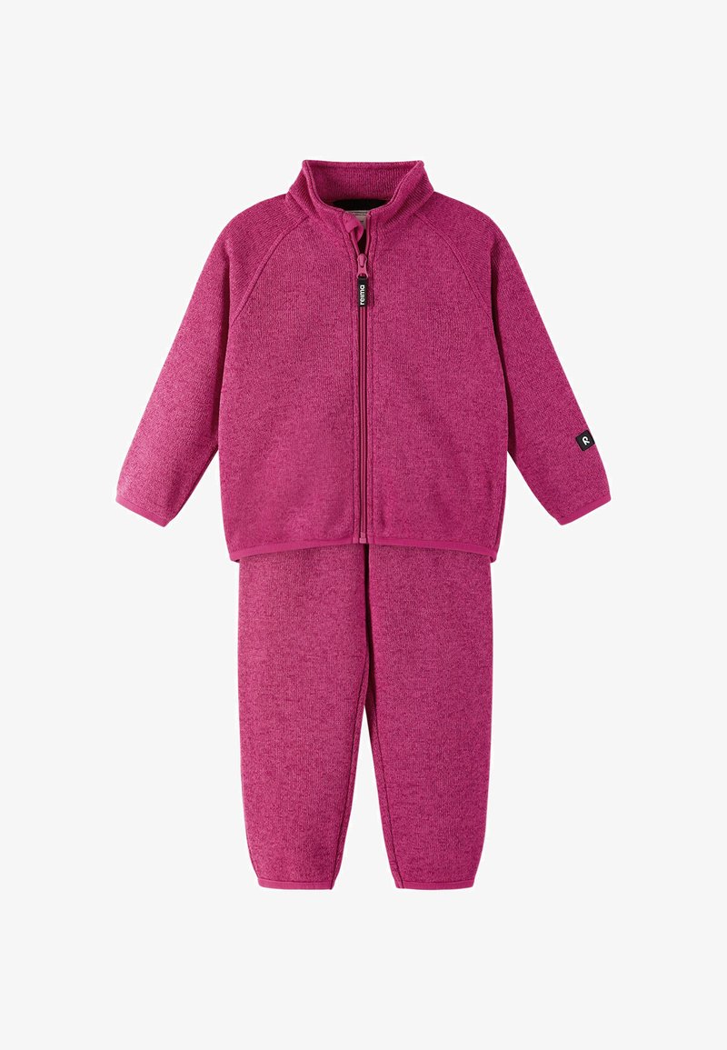 Bluza z zamkiem w kolorze fuksji z wysokim kołnierzem i długimi rękawami, zestawiona z dopasowanymi spodniami. Miękki, teksturowany materiał z niewielką ilością dodatków.