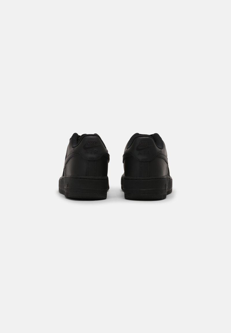 Baskets Nike noires en cuir lisse, au design bas, avec des accents texturés et une semelle en caoutchouc, vues de l'arrière.