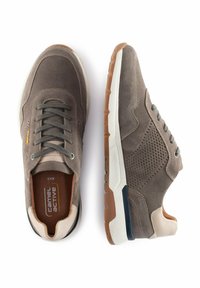 Grijze sneakers van mesh en suede materialen, met een bruine rubberen zool, beige accenten en een vetersluiting. Kenmerkende geperforeerde textuur.