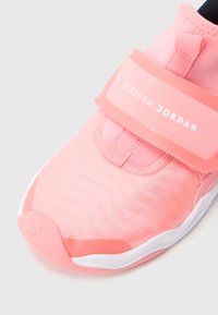 Svetlo roza superga z zgornjim delom iz teksturirane mreže, paščkom z napisom "23 SEVEN JORDAN" in gumijastim podplatom. Gladki poudarki v temnejši roza barvi.
