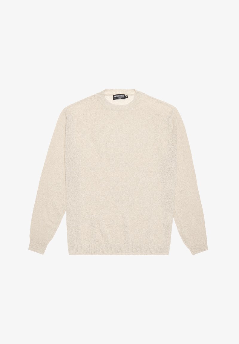 Krämfärgad tröja gjord av mjukt, texturerat material. Har långa ärmar, rund hals och ribbade muddar och fåll. Enkelt design.