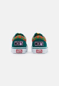 Baskets à motifs verts et oranges avec une tige en daim, semelle blanche et patchs de logo roses avec l'inscription "MOE'S". Éléments de design classiques de Vans inclus.