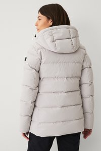Lichtgrijze pufferjack met capuchon, met doorgestikte secties, een soepele textuur en een zwart rond logo op de mouw.