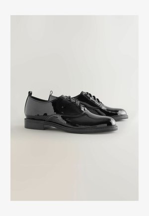 Zwarte patenten leren oxford schoenen met ronde neuzen, vetersluiting, lage hakken en een gladde reflecterende oppervlakte. Heeft een minimalistische esthetiek.