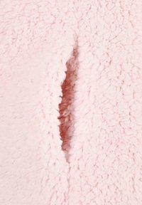 Tessuto in pile rosa con una superficie morbida e texturizzata. In evidenza c'è una fessura o apertura che rivela la texture interna.