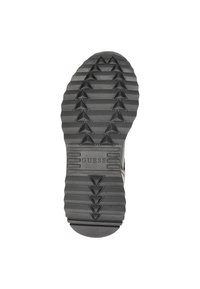 Suola di scarpa in gomma nera con un motivo a zigzag, testurizzata per una migliore presa. Presenta il logo "GUESS" su una barra orizzontale vicino al tallone.