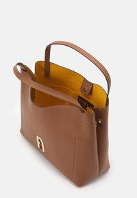 Hnědá kožená taška s texturovaným povrchem, vnitřek ve světlé žluté barvě, s zlatým logem a madly pro snadné nošení.