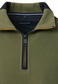 Oliwkowy sweter z zamkiem na kołnierzu, teksturowana tkanina i kontrastowe czarne i żółte akcenty. Metka mówi "CASA MODA", rozmiar M.