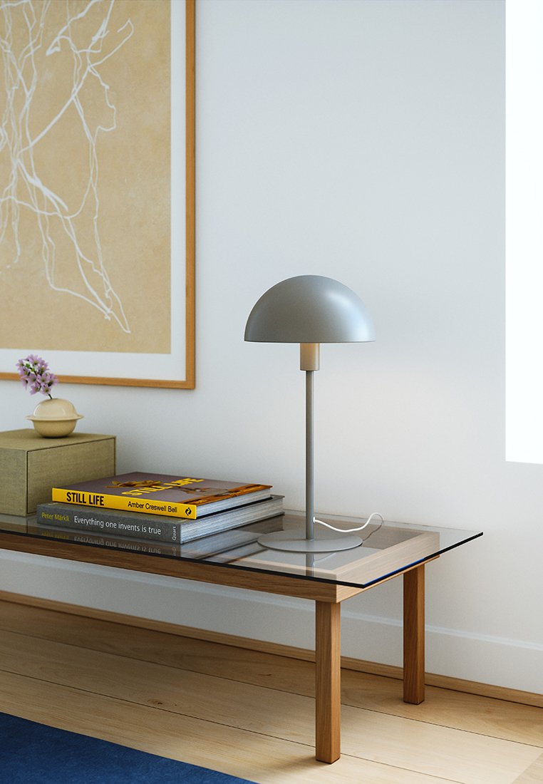 Tischlampe mit einem grauen Kuppel-Schirm und einem schlanken Fuß, auf einem Glastisch mit Büchern und einer dekorativen Box platziert.