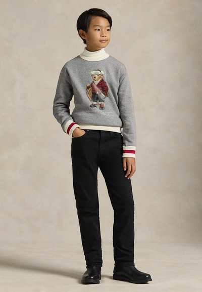 Γκρι φούτερ με σχέδιο καρτούν αρκούδας, μανσέτες με ριμπ ύφανση και κόκκινες λεπτομέρειες, συνδυασμένο με μαύρο παντελόνι και μαύρα παπούτσια. Ομαλή υφή υφάσματος.