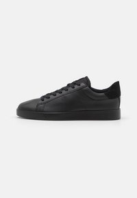 Sneaker in pelle nera con finitura liscia, punta rotonda, design con lacci e accentuazione in suede nero testurizzato sul tallone. Suola in gomma a profilo ribassato.