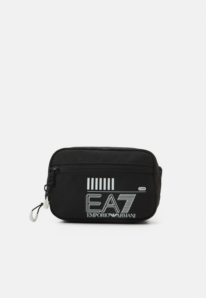 Černá nylonová taška se zipovým uzávěrem, na přední straně s bílým grafickým textem "EA7 EMPORIO ARMANI" a pruhovaným designem. Hladký povrch.