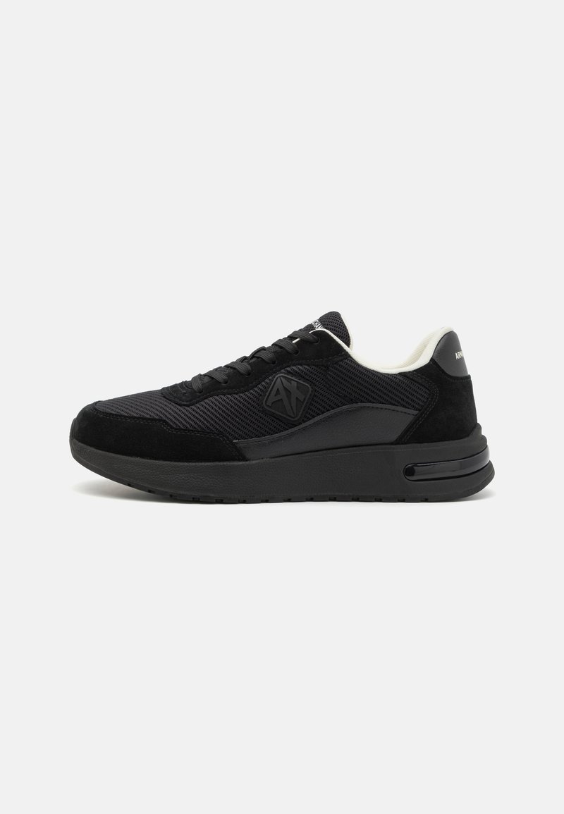 Fekete sneaker, texturált hálós felsőrésszel, velúr részletekkel, lekerekített orral, vastag talppal és logóval az oldalán.