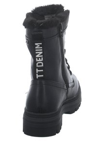 Bottines noires avec une doublure en fourrure noire douce, fermeture éclair et lettrage décoratif en argent "TT DENIM" au dos. Semelle texturée.