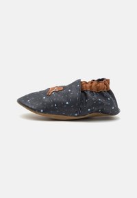 Chausson noir à motif avec un bout pointu, doté d'un col froncé marron et d'un design imprimé avec des accents bleu clair et bleu foncé.