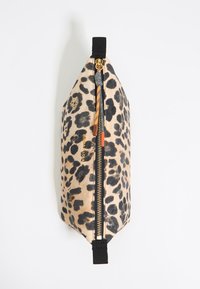 Kozmetická taška s leopardím vzorom vyrobená z jemného materiálu, s ozdobným zlatým zipsom, čiernymi textilnými akcentmi a zúženým dizajnom. Jej dĺžka je približne 25 cm.