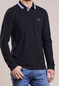 Black long-sleeve polo shirt with a striped collar in blue and white, featuring a subtle logo on the left chest and a smooth texture.