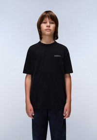 T-shirt en coton noir à manches courtes et col rond. Présente un petit logo à l'avant. Associé à un pantalon texturé sombre.