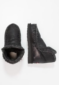 Zwarte leren enkelboots met een grijze faux fur voering, gestikte randen en een platte rubberen zool. Gladde, gestructureerde oppervlakte met een afgeronde teenton.