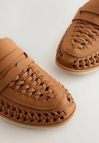Braune, gewebte Leder-Pantoffeln mit runder Zehenform und strukturierten Akzenten. Sie verfügen über eine flache Sohle und ein kunstvolles geflochtenes Design.