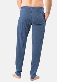Pantalons de pyjama rayés bleus et blancs avec une taille élastique et des poches latérales, présentant un design à jambe fuselée et une texture douce.