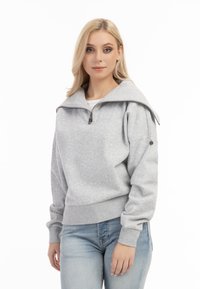 Grijze sweatvest met hoge kraag en een half-rits ontwerp. Voorzien van ribbelboorden en een ribbelzoom, subtiele textuur en details op de schoudernaad.