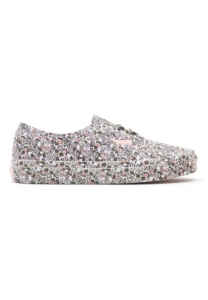 Floral canvas sneakers feature a white, pink, and green pattern, rounded toes, and white rubber soles with minimal hardware accents.