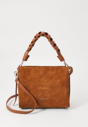 Barna velúr kézitáska fonott bőr fogantyúval, ezüst színű fémrészekkel és állítható vállpánttal. Simább felület és minimalista téglalap alakú dizájn jellemzi.