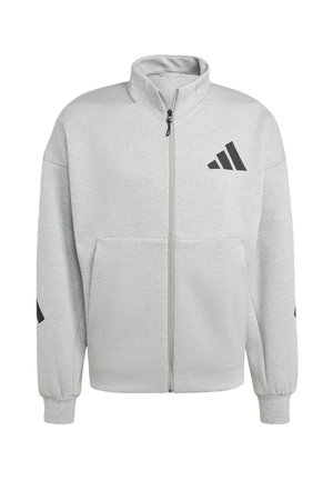 Grå zip-up sweatshirt med høj krave, forlommer, sort logo på venstre bryst og diskrete sorte detaljer på ærmerne. Blødt stofsstruktur.