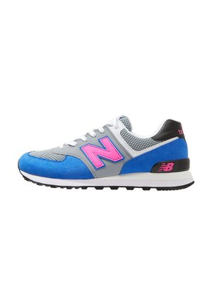 Lage sportieve sneaker met blauwe suède, grijze meshpanelen, witte veters en een felroze New Balance "N"-logo aan de zijkant.