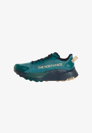 Scarpa da trail running The North Face turchese e nera con dettagli beige, design a griglia sulla suola e chiusura con lacci.