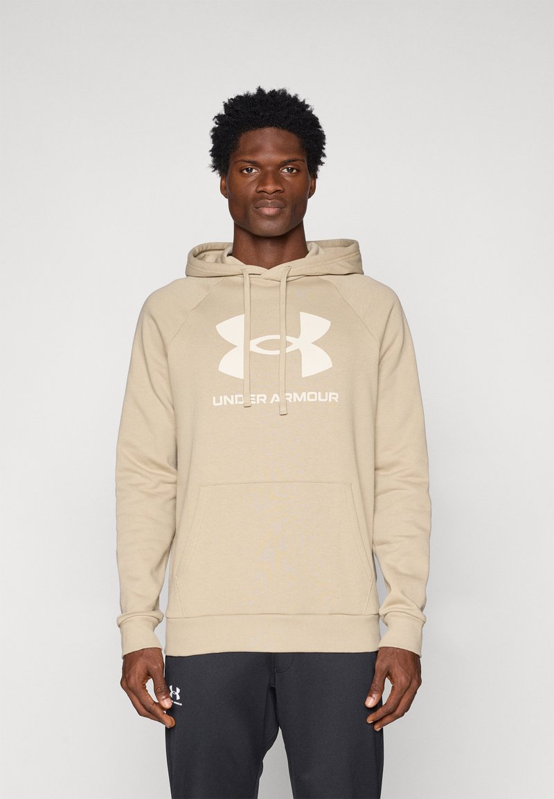 Felpa con cappuccio beige con tasca frontale, caratterizzata da un grande logo Under Armour bianco e maniche raglan. Texture morbida, design casual.