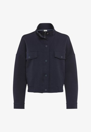 Marineblå jakke med høj krave, lange ærmer, forside med trykknapper og to brystlommer med klap og trykknaplukning.