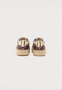 Sneakers espadryle w panterkę z złotym metalowym akcentem na obcasie i plecioną juty podeszwą. Cechują się gładką teksturą i zaokrąglonym kształtem.