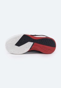 Suela de zapatilla negra con patrones texturizados en acentos blancos y rojos, con diseños geométricos para tracción y estabilidad.