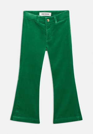 Pantalon en velours côtelé vert pour enfants, jambes évasées, fermeture par bouton et zip, passants pour ceinture avec étiquette Mini Rodini à l'intérieur de la ceinture.