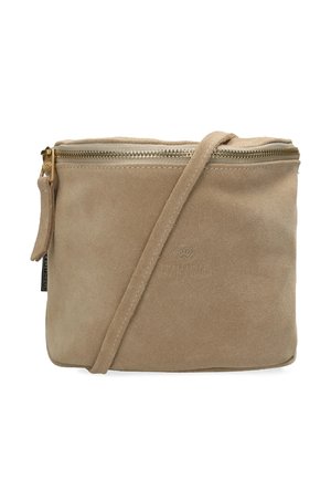 Bolso bandolera de ante beige con cierre de cremallera, correa ajustable y logo grabado en relieve en el frente; textura suave y diseño minimalista.