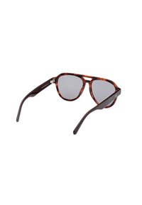 Occhiali da sole tartarugati con lenti grigie, caratterizzati da una montatura geometrica, aste eleganti e un marchio discreto sulla tempia.