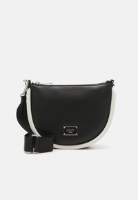 Bolso bandolera de imitación cuero negro con un diseño curvado, acentos en blanco, herrajes plateados y una placa con el logotipo en la parte frontal. Correa ajustable.
