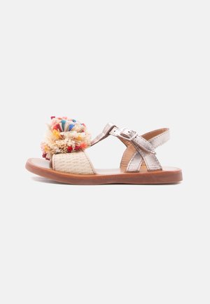 Sandale pour enfant à bout ouvert avec des brides métalliques, une boucle latérale, une semelle tissée, une semelle marron et une décoration pompon multicolore sur le devant.