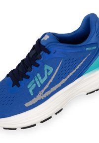 Blauwe sportieve schoen met een bovenwerk van mesh, voorzien van een zilveren swoosh ontwerp, zwarte rubberen zool en getextureerde accenten. Het logo leest "FILA" in lichtgroen.