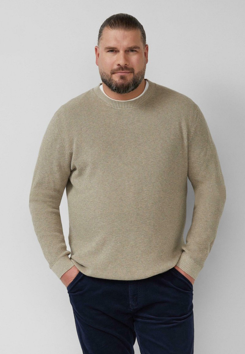 Beige gebreide trui met een ronde halslijn, textuurgaren en lange mouwen, gecombineerd met donkerblauwe broek. Casual, comfortabele pasvorm.