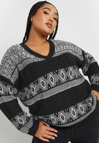 Schwarzer und grauer Strickpullover mit V-Ausschnitt, Zopfmuster und geometrischen Mustern, langen Ärmeln und lockerem Schnitt.