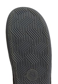 Zwarte rubberen schoenzool met een zigzagpatroon, met een cirkelvormig logo in het midden onderaan, gestructureerd voor grip en duurzaamheid.