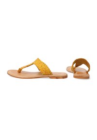 Vævede gule lædersandaler med en flad brun sål, der har et flettet stropdesign og en sandalstrop i mellemrum.