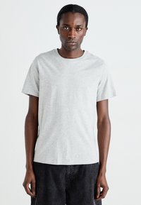 Grå bomulds t-shirt med rund hals, korte ærmer og en let stræk. Stoffet har en glat tekstur og et minimalistisk design.