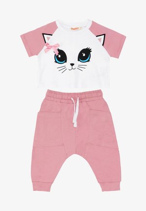 Weißes T-Shirt mit kurzen Ärmeln und pinken Akzenten sowie einem Katzen-Gesicht-Design, kombiniert mit pinken Jogginghosen mit seitlichen Taschen und einem Kordelzugbund.