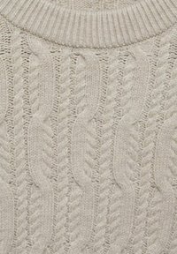 Helles beige Strickpullover mit einem Zopfmuster, ausgestattet mit einem strukturierten, gerippten Kragenbereich. Der Stoff wirkt weich und warm.